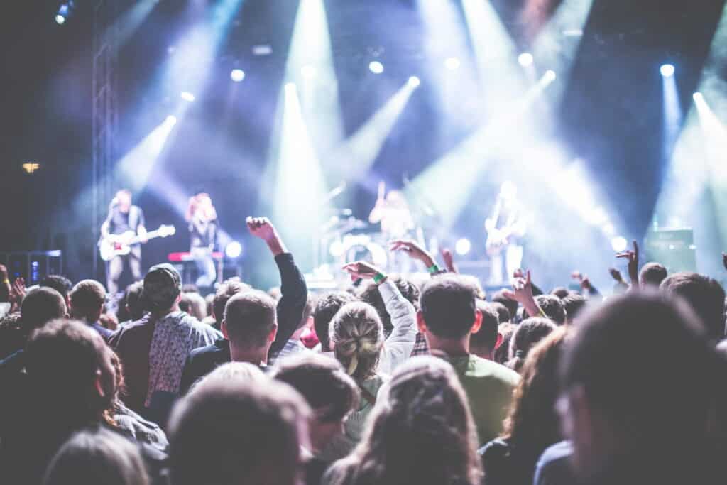 Concert crowd with band and stage lights in the background