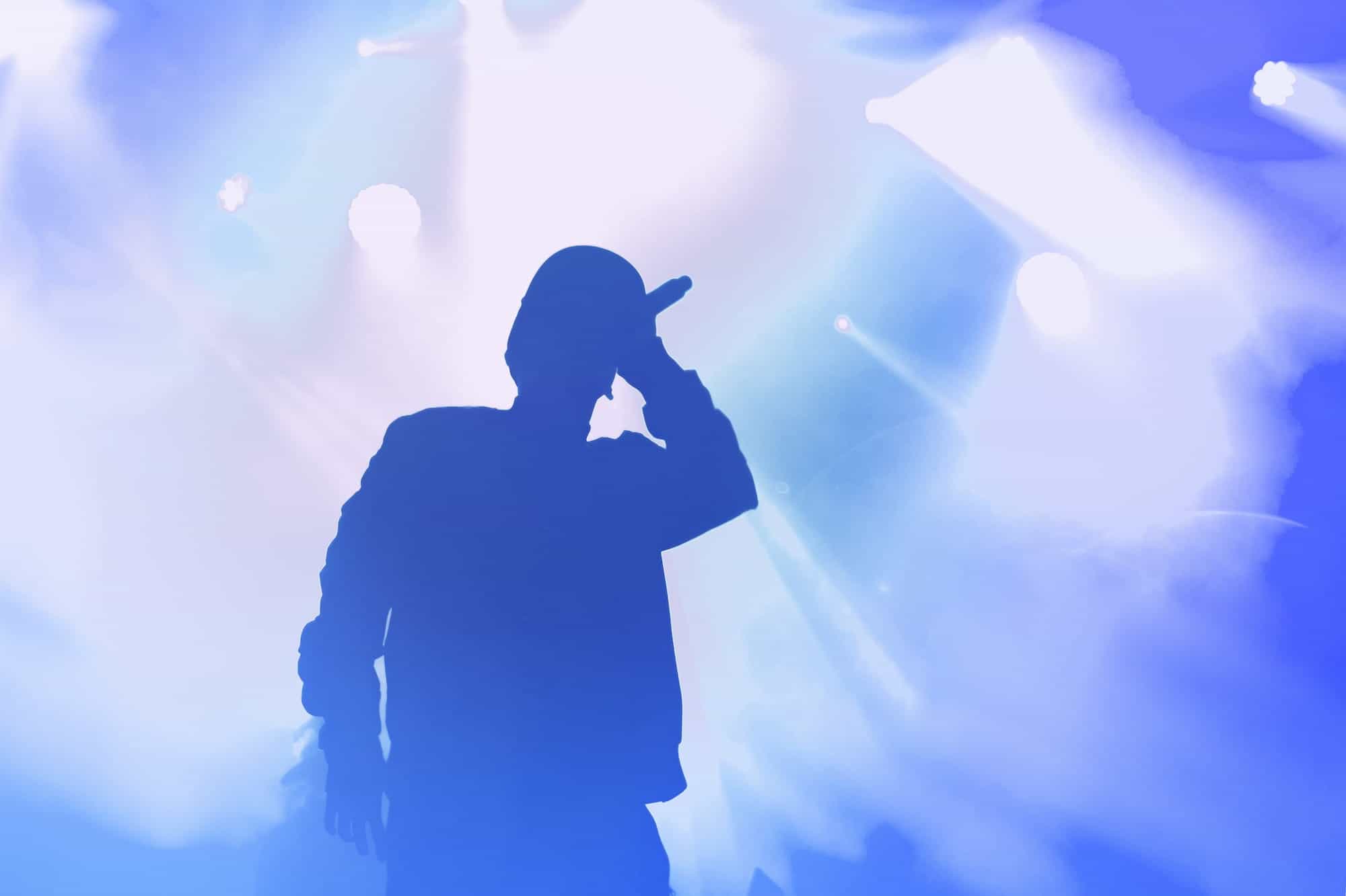 Man singing with microphone and lights in the background
