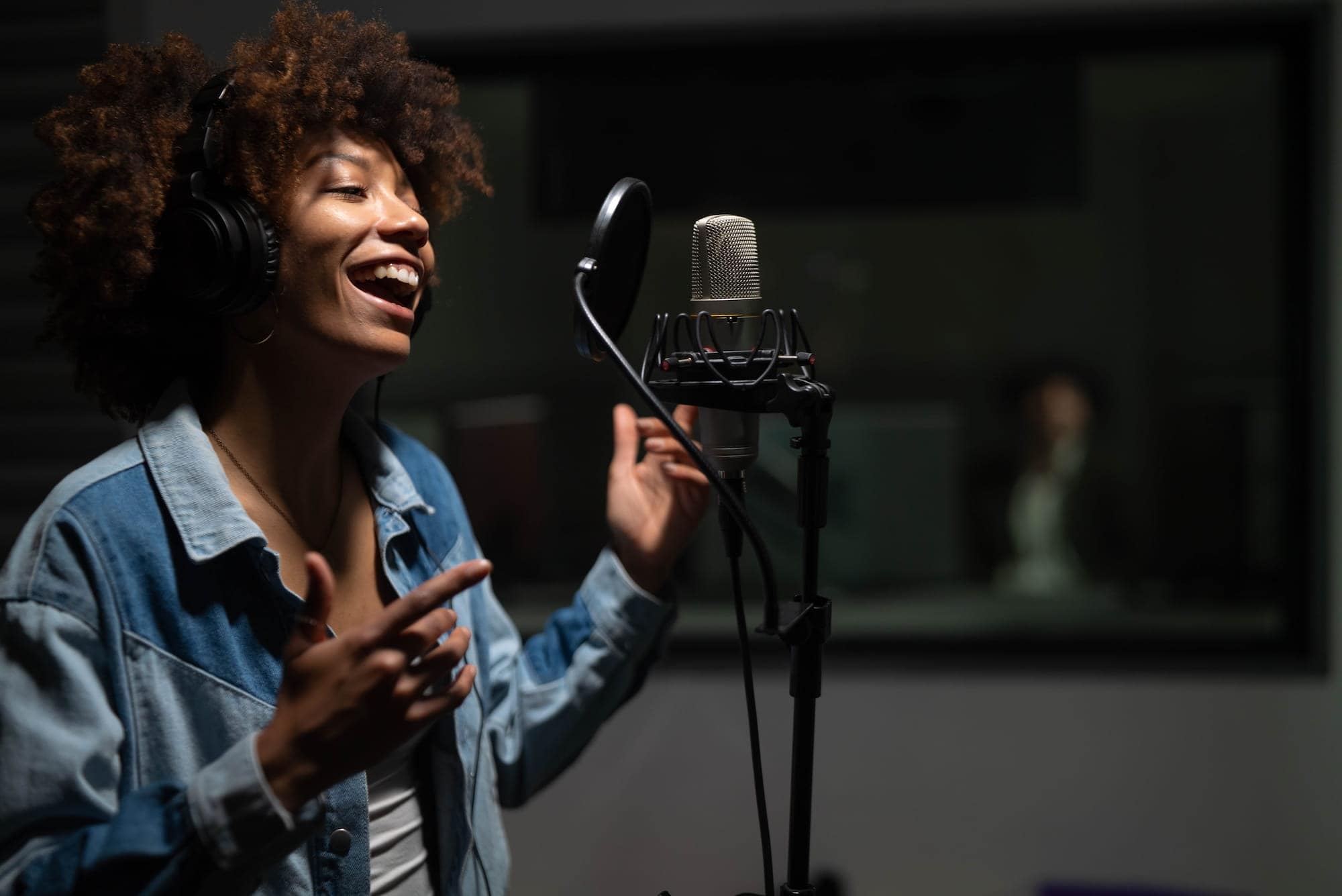 Woman singing and hitting a high note in a studio